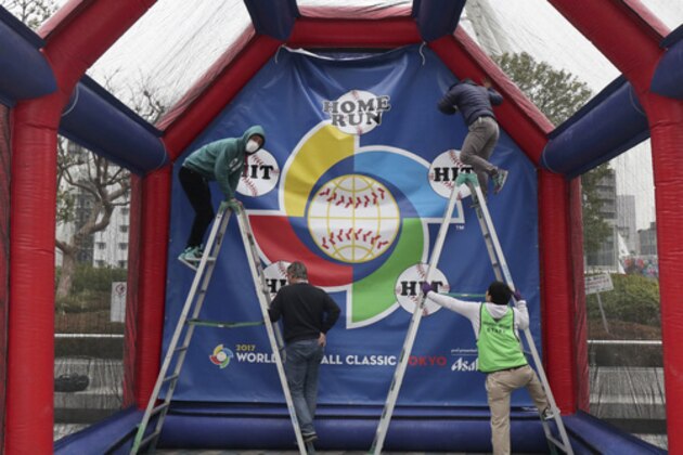 Workers set up an attraction of baseball with the logo of the World Baseball Classic at Tokyo Dome in Tokyo, Monday, March 6, 2017. The Group B first round games of the WBC played by Australia, China, Cuba and Japan will start on Tuesday at the indoor stadium. (AP Photo/Shizuo Kambayashi)