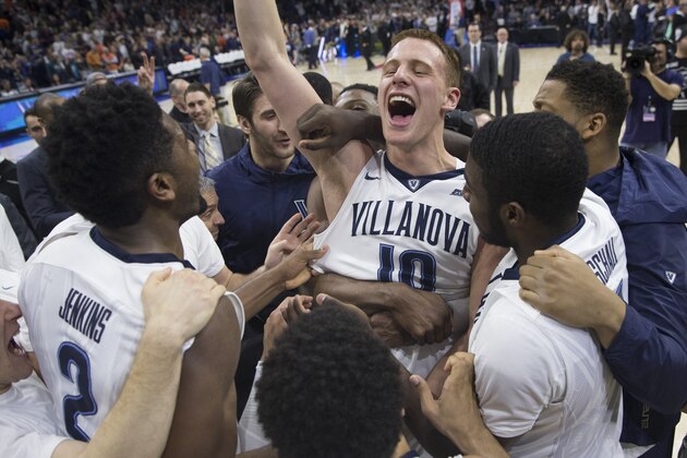 PHILADELPHIA, PA - JANUARY 29: Donte DiVincenzo #10 of the Villanova Wildcats celebrates with Jalen Brunson #1, Eric Paschall #4, Darryl Reynolds #45, and the rest of his team after tipping in the game winning basket as time expired against the Virginia Cavaliers at the Wells Fargo Center on January 29, 2017 in Philadelphia, Pennsylvania. The Wildcats defeated the Cavaliers 61-59. (Photo by Mitchell Leff/Getty Images)