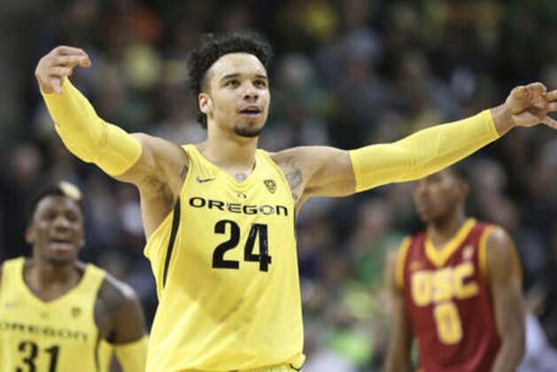 Oregon's Dillon Brooks, center, celebrates after scoring against Southern California during the second half of an NCAA college basketball game Friday, Dec. 30, 2016, in Eugene, Ore. At rear are Oregon's Dylan Ennis, left, and Southern California's Shaqquan Aaron, (AP Photo/Chris Pietsch)
