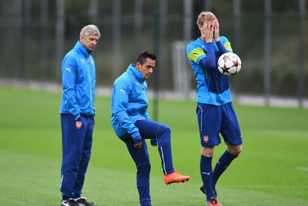 ST ALBANS, ENGLAND - AUGUST 26:  Alexis Sanchez of Arsenal passes the ball as manager Arsene Wenger and Per Mertesacker look on during a training session at London Colney on August 26, 2014 in St Albans, England.  (Photo by Shaun Botterill/Getty Images)