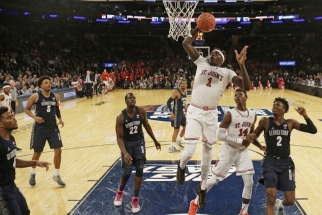 St. John's Bashir Ahmed (1) dunks as Georgetown's Jonathan Mulmore (2) and Akoy Agau (22) watch during the first half of an NCAA college basketball game during the Big East men's tournament Wednesday, March 8, 2017, in New York. (AP Photo/Frank Franklin II)
