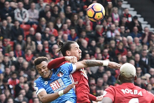 Manchester United's Swedish striker Zlatan Ibrahimovic (C) clashes in the air with Bournemouth's English defender Tyrone Mings (L) during the English Premier League football match between Manchester United and Bournemouth at Old Trafford in Manchester, north west England, on March 4, 2017. / AFP PHOTO / Oli SCARFF / RESTRICTED TO EDITORIAL USE. No use with unauthorized audio, video, data, fixture lists, club/league logos or 'live' services. Online in-match use limited to 75 images, no video emulation. No use in betting, games or single club/league/player publications.  /         (Photo credit should read OLI SCARFF/AFP/Getty Images)