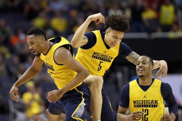 WASHINGTON, DC - MARCH 09: Zak Irvin #21, D.J. Wilson #12, and Muhammad-Ali Abdur-Rahkman #12 of the Michigan Wolverines celebtrate after Wilson scored in the first half against the Illinois Fighting Illini during the Big Ten Basketball Tournament at Verizon Center on March 9, 2017 in Washington, DC.  (Photo by Rob Carr/Getty Images)
