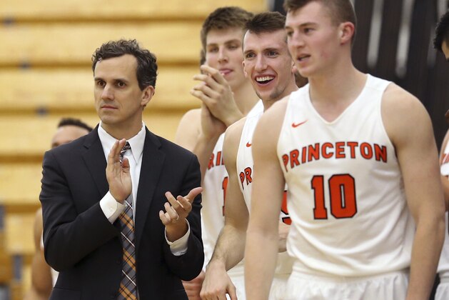 FILE - In this Nov. 25, 2016, file photo, Princeton coach Mitch Henderson applauds as he stands with his players during the second half of an NCAA college basketball game against Rowan in Princeton, N.J. As the first team to go 14-0 in Ivy League play and not automatically qualify for the NCAA Tournament, Princeton has earned a somewhat dubious distinction in league history. Were it any previous year, the Tigers would be eagerly awaiting Selection Sunday. However, the Ivy became the nation’s final league to employ a conference tournament to decide its automatic qualifier, so Princeton (21-6) still needs two wins in Philadelphia this weekend to reach the NCAAs. (AP Photo/Mel Evans, File)
