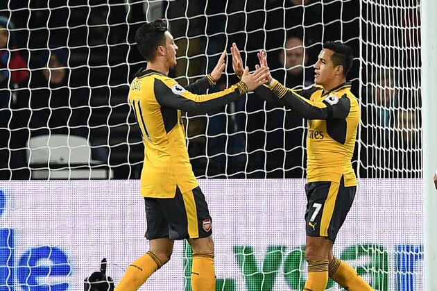 Arsenal's German midfielder Mesut Ozil (L) celebrates with Arsenal's Chilean striker Alexis Sanchez after scoring the opening goal of the English Premier League football match between West Ham United and Arsenal at The London Stadium, in east London on December 3, 2016. / AFP / Justin TALLIS / RESTRICTED TO EDITORIAL USE. No use with unauthorized audio, video, data, fixture lists, club/league logos or 'live' services. Online in-match use limited to 75 images, no video emulation. No use in betting, games or single club/league/player publications.  /         (Photo credit should read JUSTIN TALLIS/AFP/Getty Images)