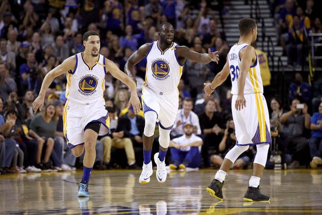 OAKLAND, CA - OCTOBER 04:  Klay Thompson #11 and Stephen Curry #30 congratulate Draymond Green #23 of the Golden State Warriors after he made a basket against the Los Angeles Clippers during their preseason game at ORACLE Arena on October 4, 2016 in Oakland, California.  NOTE TO USER: User expressly acknowledges and agrees that, by downloading and or using this photograph, User is consenting to the terms and conditions of the Getty Images License Agreement.  (Photo by Ezra Shaw/Getty Images)