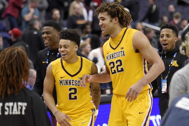 Minnesota center Reggie Lynch (22) and guard Nate Mason (2) react as they leave the court after an NCAA college basketball game against Michigan State in the Big Ten tournament, Friday, March 10, 2017, in Washington. Minnesota won 63-58. (AP Photo/Nick Wass)