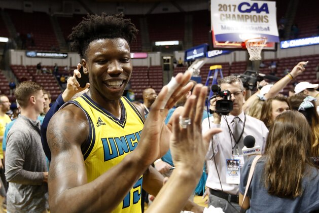 UNC Wilmington's Devontae Cacok celebrates with fans after defeating College of Charleston 78-69 at the end of an NCAA college championship basketball game in the Colonial Athletic Association tournament at the North Charleston Coliseum in North Charleston, S.C., Monday, March 6, 2017. (AP Photo/Mic Smith)