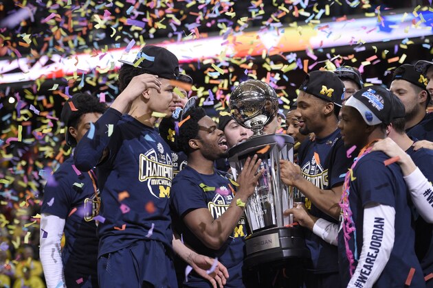 Michigan celebrates with the trophy after the Big Ten NCAA college basketball championship game against Wisconsin, Sunday, March 12, 2017, in Washington. Michigan won 71-56. (AP Photo/Nick Wass)