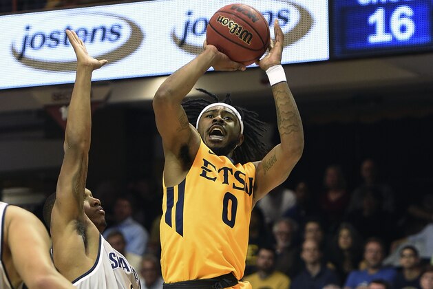East Tennessee State's guard T.J. Cromer (0) shoots over UNC Greensboro's forward James Dickey (21) during the first half of an NCAA college basketball game for the Southern Conference tournament championship in Asheville, N.C., Monday, March 6, 2017. East Tennessee State won 79-74. (AP Photo/Kathy Kmonicek)