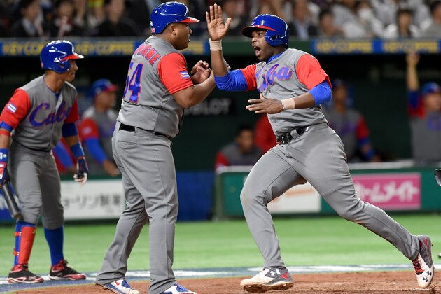 Cuba's outfieler William Saavedra (R) and Alfredo Despaigne (C) celebrate at the home plate following a two-run single of right fielder Victor Mesa in the top of the fourth inning during the World Baseball Classic Pool E second round match between Cuba and Japan at Tokyo Dome in Tokyo on March 14, 2017. / AFP PHOTO / TORU YAMANAKA        (Photo credit should read TORU YAMANAKA/AFP/Getty Images)