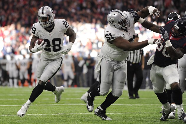 Oakland Raiders running back Latavius Murray (28) moves through a hols on the line against the Houston Texans during the first half of an AFC Wild Card NFL game Saturday, Jan. 7, 2017, in Houston. Murray scored a touchdown on the play. (AP Photo/Eric Christian Smith)