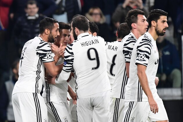 Juventus' forward from Argentina Paulo Dybala (2ndL) is congratulated by teammates after scoring a penalty during the UEFA Champions League football match Juventus vs FC Porto on March 14, 2017 at the Juventus stadium in Turin. / AFP PHOTO / MIGUEL MEDINA        (Photo credit should read MIGUEL MEDINA/AFP/Getty Images)