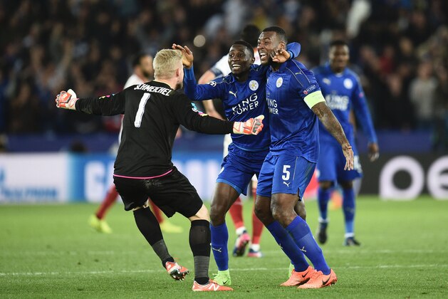 Leicester City's Nigerian midfielder Wilfred Ndidi (C), Leicester City's English-born Jamaican defender Wes Morgan (R) and Leicester City's Danish goalkeeper Kasper Schmeichel (L) celebrate their victory at the final whistle during the UEFA Champions League round of 16 second leg football match between Leicester City and Sevilla at the King Power Stadium on March 14, 2017. / AFP PHOTO / Oli SCARFF        (Photo credit should read OLI SCARFF/AFP/Getty Images)