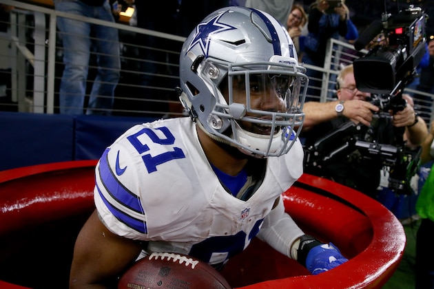ARLINGTON, TX - DECEMBER 18:  Ezekiel Elliott #21 of the Dallas Cowboys celebrates after scoring a touchdown by jumping into a Salvation Army red kettle during the second quarter against the Tampa Bay Buccaneers at AT&T Stadium on December 18, 2016 in Arlington, Texas.  (Photo by Tom Pennington/Getty Images)