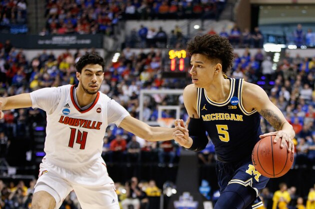 INDIANAPOLIS, IN - MARCH 19:  D.J. Wilson #5 of the Michigan Wolverines drives against Anas Mahmoud #14 of the Louisville Cardinals in the first half during the second round of the 2017 NCAA Men's Basketball Tournament at the Bankers Life Fieldhouse on March 19, 2017 in Indianapolis, Indiana.  (Photo by Joe Robbins/Getty Images)