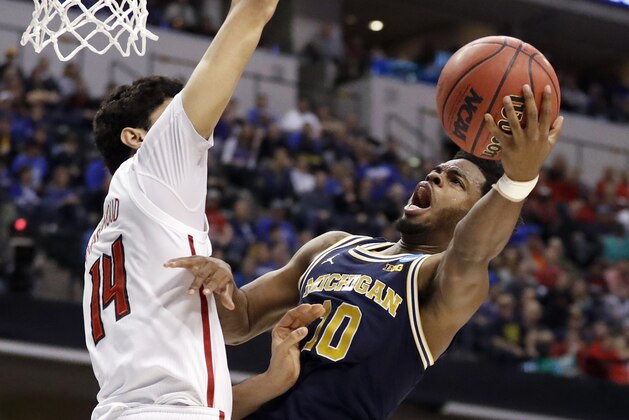 Michigan's Derrick Walton Jr. (10) heads to the basket as Louisville's Anas Mahmoud defends during the first half of a second-round game in the men's NCAA college basketball tournament Sunday, March 19, 2017, in Indianapolis. (AP Photo/Jeff Roberson)