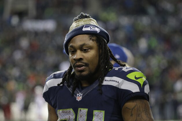 Seattle Seahawks running back Marshawn Lynch talks to teammates on the sideline in the second half of an NFL football game against the Arizona Cardinals, Sunday, Nov. 15, 2015, in Seattle. (AP Photo/Elaine Thompson)