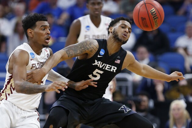 Florida State guard Xavier Rathan-Mayes, left, bats the ball away from Xavier guard Trevon Bluiett (5) during the second half of a second-round game in the NCAA men's college basketball tournament, Saturday, March 18, 2017, in Orlando, Fla. Xavier defeated Florida State 91-66. (AP Photo/Wilfredo Lee)