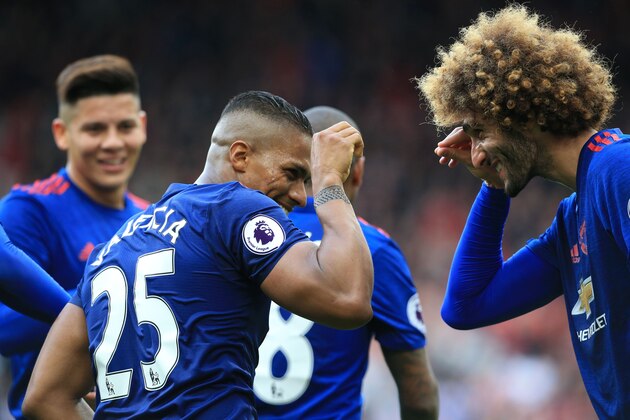 Manchester United's Ecuadorian midfielder Antonio Valencia (2nd L) celebrates with Manchester United's Belgian midfielder Marouane Fellaini (R) after scoring their third goal during the English Premier League football match between Middlesbrough and Manchester United at Riverside Stadium in Middlesbrough, north east England on March 19, 2017.
Manchester United won the game 3-1. / AFP PHOTO / Lindsey PARNABY / RESTRICTED TO EDITORIAL USE. No use with unauthorized audio, video, data, fixture lists, club/league logos or 'live' services. Online in-match use limited to 75 images, no video emulation. No use in betting, games or single club/league/player publications.  /         (Photo credit should read LINDSEY PARNABY/AFP/Getty Images)