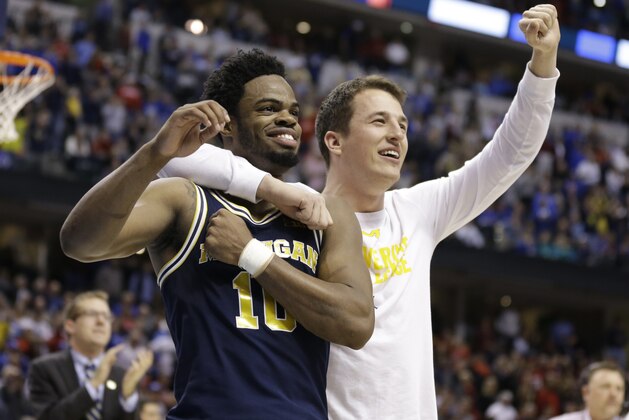 Michigan guard Derrick Walton Jr. (10) and guard Andrew Dakich (11) celebrate following a 73-69 win over Louisville in a second-round game in the men’s NCAA college basketball tournament in Indianapolis, Sunday, March 19, 2017.  (AP Photo/Michael Conroy)