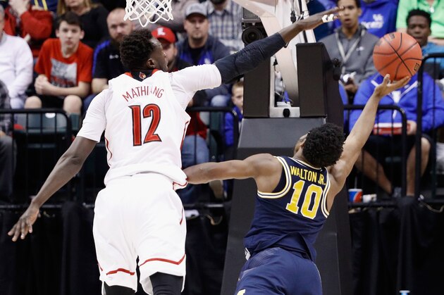INDIANAPOLIS, IN - MARCH 19:  Mangok Mathiang #12 of the Louisville Cardinals attempts to block a shot by Derrick Walton Jr. #10 of the Michigan Wolverines in the second half during the second round of the 2017 NCAA Men's Basketball Tournament at the Bankers Life Fieldhouse on March 19, 2017 in Indianapolis, Indiana.  (Photo by Joe Robbins/Getty Images)