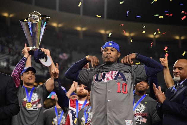 LOS ANGELES, CA - MARCH 22:  Adam Jones #10 of team United States shoes his USA shirt while teammate Giancarlo Stanton #27 holds the trophy after their 8-0 win over team Puerto Rico during Game 3 of the Championship Round of the 2017 World Baseball Classic at Dodger Stadium on March 22, 2017 in Los Angeles, California.  (Photo by Harry How/Getty Images)