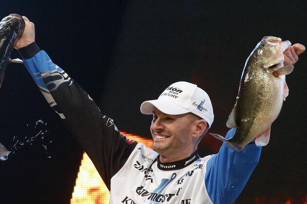 Randy Howell, Springville, Ala., holds up two bass at a weigh-in, Sunday Feb. 23, 2014 in Birmingham, Ala. that helped him win the Bassmaster Classic on Lake Guntersville. (AP Photo/Hal Yeager)