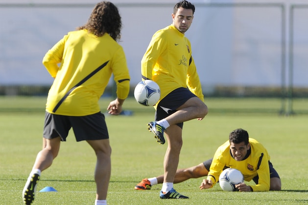 Spain's FC Barcelona Carles Puyol (L), Xavi (C) and Dani Alves (R) take part in a training in Yoikohama, suburban Tokyo, on December 12, 2011. FC Barcelona will play against Asian champion Qatar's Al-Ssad at the semi-final of the FIFA Club World Cup here on December 14.    AFP PHOTO/Toru YAMANAKA (Photo credit should read TORU YAMANAKA/AFP/Getty Images)