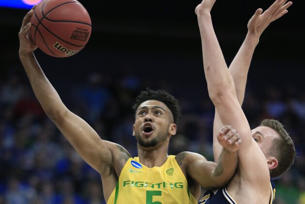 Oregon guard Tyler Dorsey (5) drives to the basket past Michigan guard Duncan Robinson during the first half of a regional semifinal of the NCAA men's college basketball tournament, Thursday, March 23, 2017, in Kansas City, Mo. (AP Photo/Orlin Wagner)