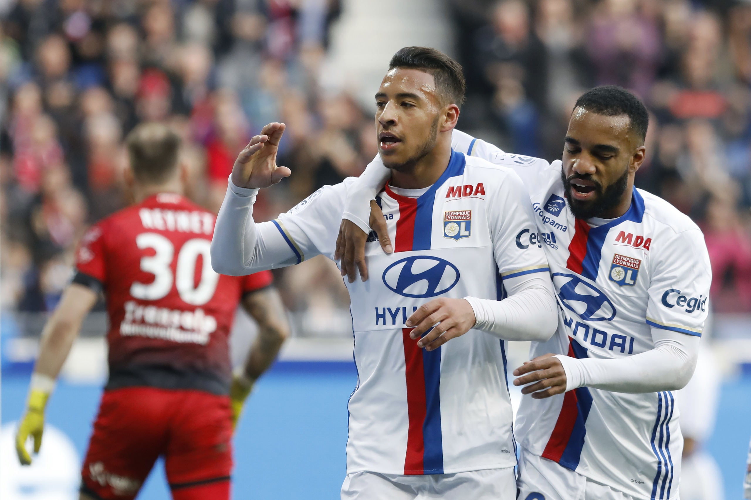 Lyon's Corentin Tolisso, center, celebrates with Alexandre Lacazette, right, after he scored a goal against Dijon during their French League One soccer match in Decines, near Lyon, central France, Sunday, Feb. 19, 2017. (AP Photo/Laurent Cipriani)