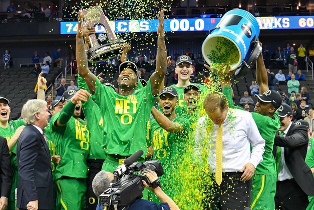 Mar 25, 2017; Kansas City, MO, USA; Oregon Ducks head coach Dana Altman is doused by confetti by his players as they celebrate with the trophy after the game against the Kansas Jayhawks in the finals of the Midwest Regional of the 2017 NCAA Tournament at Sprint Center. Oregon defeated Kansas 74-60. Mandatory Credit: Denny Medley-USA TODAY Sports