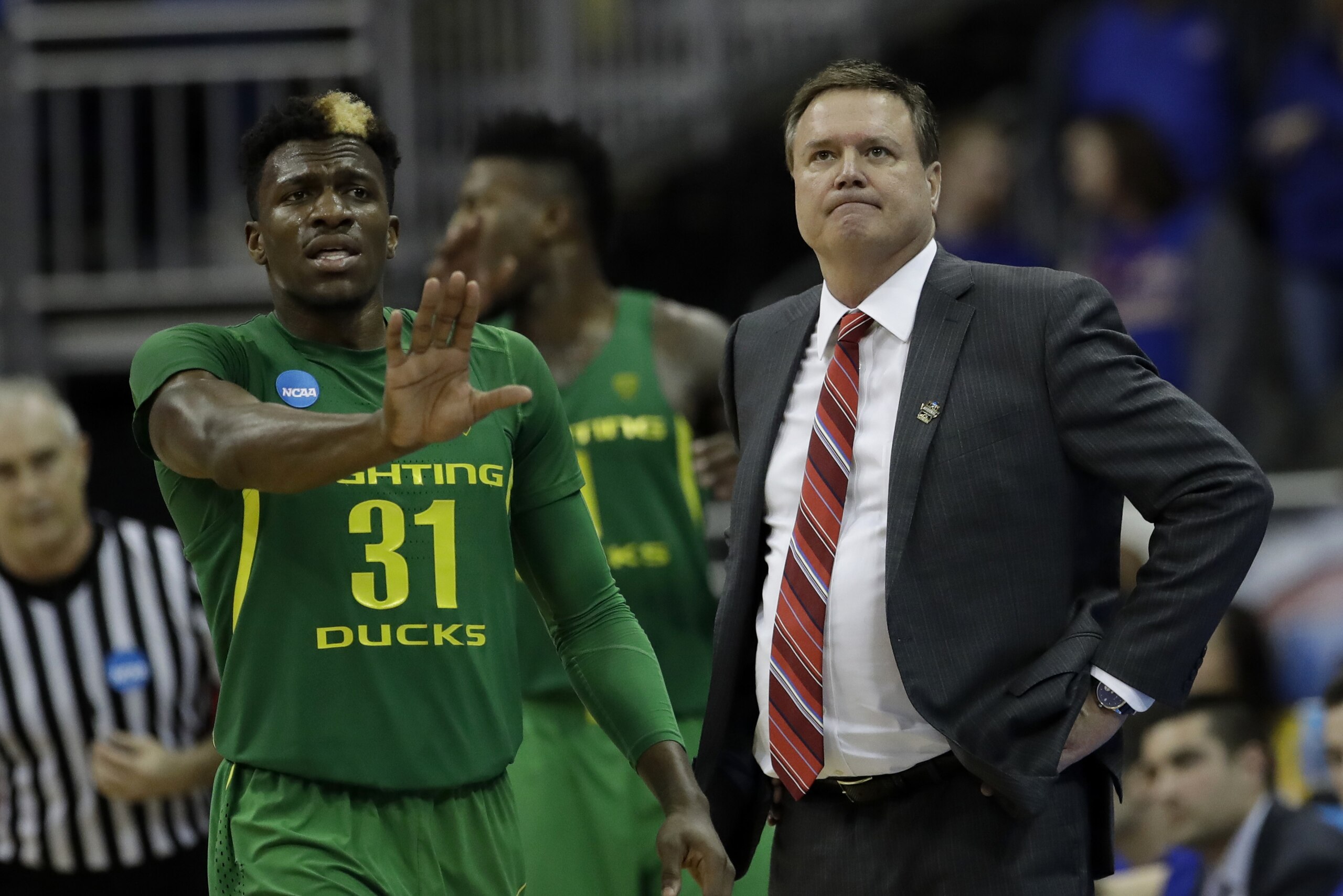 Kansas head coach Bill Self, right, watches from the bench in front of Oregon guard Dylan Ennis, left, during the second half of a regional final of the NCAA men's college basketball tournament, Saturday, March 25, 2017, in Kansas City, Mo. Oregon won 74-60. (AP Photo/Charlie Riedel) Kansas head coach Bill Self, right, watches from the bench in front of Oregon guard Dylan Ennis, left, during the second half of a regional final of the NCAA men's college basketball tournament, Saturday, March 25, 2017, in Kansas City, Mo. Oregon won 74-60. (AP Photo/Charlie Riedel)