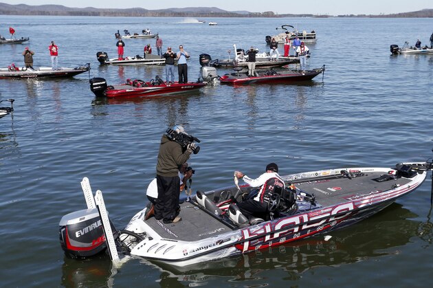 Randall Tharp, Port Saint Joe, Fla., holds up a bass for spectators following him on the second day of the Bassmaster Classic, Saturday, Feb. 22, 2014, in Guntersville, Ala. Tharp was bumped from first to second by 1 ounce by Edwin Evers, Talala, Okla. The field will be cut to the top 25 anglers for the final day of competition. (AP Photo/Hal Yeager)