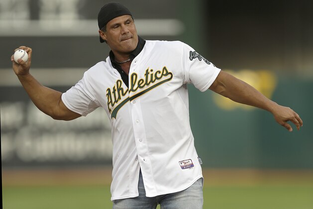 Former Oakland Athletics player Jose Canseco throws out the ceremonial first pitch prior to a baseball game against the Boston Red Sox, Saturday, Sept. 3, 2016, in Oakland, Calif. (AP Photo/Ben Margot)