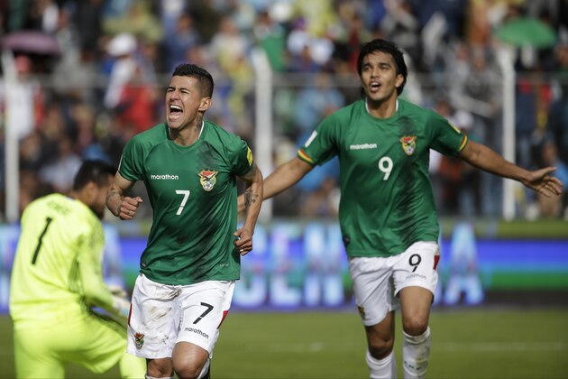 Bolivia's Juan Carlos Arce (7) celebrates scoring his side's first goal against Argentina, followed by teammate Marcelo Martins, during a 2018 World Cup qualifying match in La Paz, Bolivia, on Tuesday, March 28, 2017. (AP Photo/Victor R. Caivano)