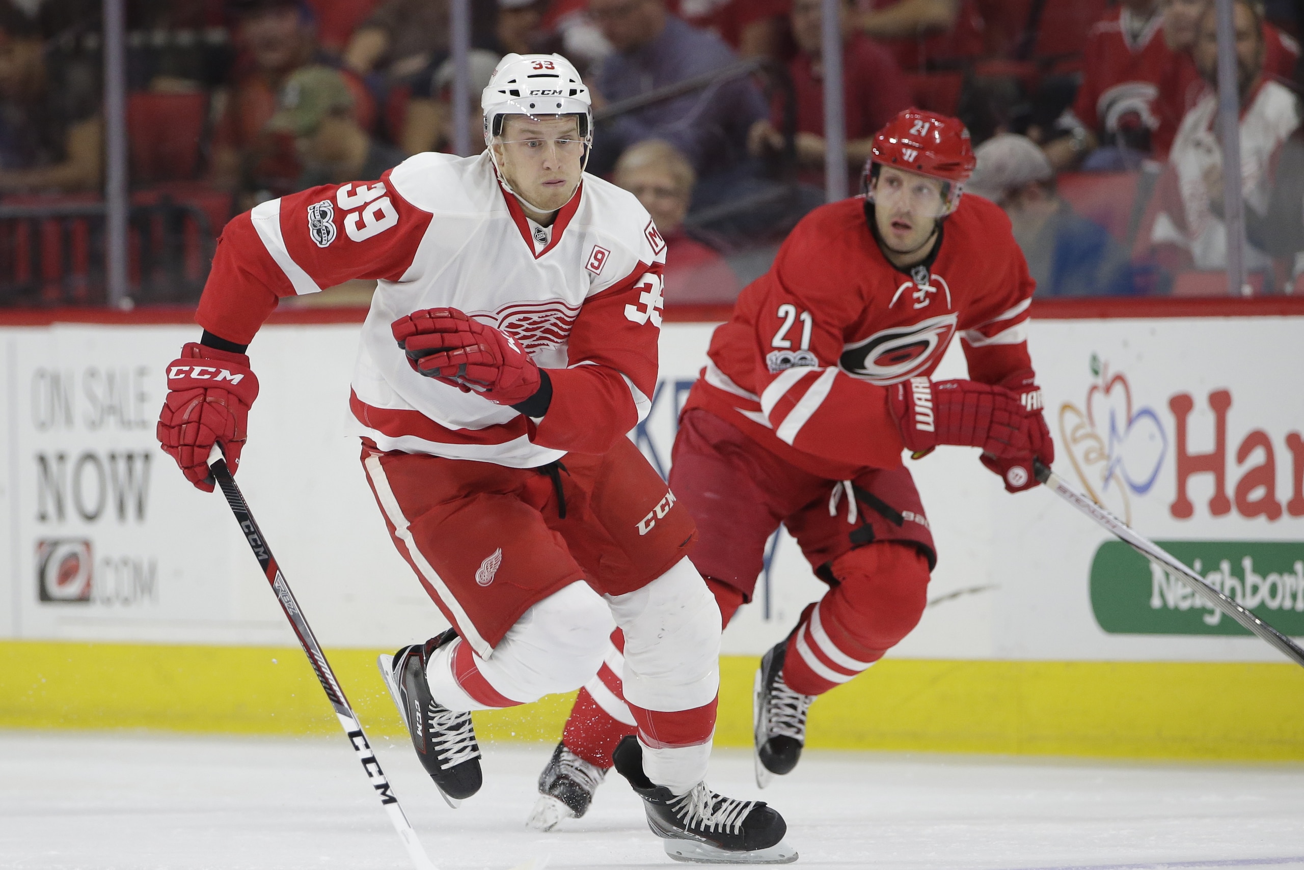 Detroit Red Wings' Anthony Mantha (39) and Carolina Hurricanes' Lee Stempniak (21) chase the puck during the first period of an NHL hockey game in Raleigh, N.C., Tuesday, March 28, 2017. (AP Photo/Gerry Broome)