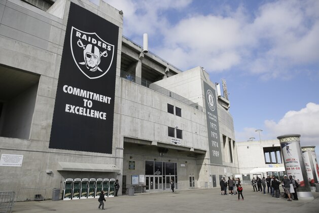 Two boys throw a football outside the Oakland Coliseum before the start of a rally to keep the Oakland Raiders from moving Saturday, March 25, 2017, in Oakland, Calif. NFL owners are expected to vote on the team's possible relocation to Las Vegas Monday or Tuesday at their meeting in Phoenix. (AP Photo/Eric Risberg)