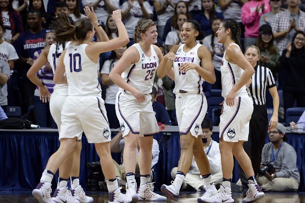 In this Tuesday, Nov. 1, 2016 photo, Connecticut's Gabby Williams, second from right, is greeted by her teammates after making a basket during an NCAA college basketball exhibition game against Indiana University of Pennsylvania in Storrs, Conn. UConn’s “Big Three” won an NCAA record 151 games during their college careers, but their departure doesn’t exactly leave the Huskies’ closet bare. (AP Photo/Jessica Hill)