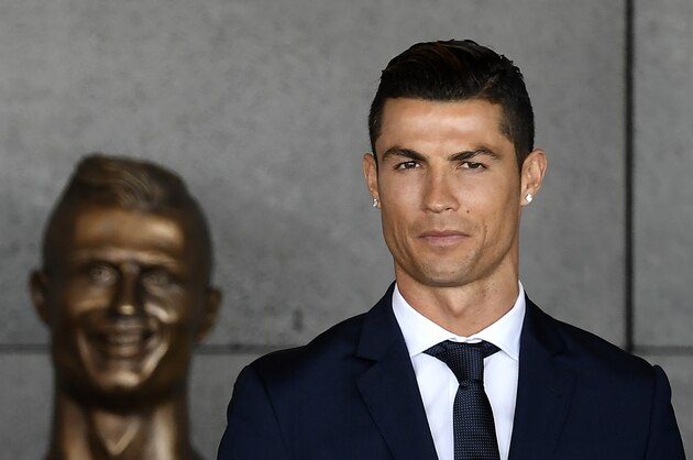 TOPSHOT - Portuguese footballer Cristiano Ronaldo stands past a bust presented during a ceremony where Madeira's airport in Funchal is to be renamed after Cristiano Ronaldo, on Madeira island, on March 29, 2017.
Madeira airport, the birthplace of Portuguese footballer Cristiano Ronaldo, was renamed today in honor of the quadruple Ballon d'or and captain of the Portuguese team sacred European champion last summer. / AFP PHOTO / FRANCISCO LEONG        (Photo credit should read FRANCISCO LEONG/AFP/Getty Images)