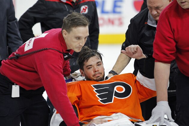 Philadelphia Flyers goalie Michal Neuvirth gives a thumbs-up as he is taken off the ice on a stretcher after collapsing to the ice early in the first period of the team's NHL hockey game against the New Jersey Devils, Saturday, April 1, 2017, in Philadelphia. (AP Photo/Tom Mihalek)