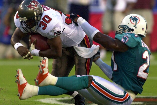 Miami Dolphins safety Antuan Edwards, right, grabs ahold of Tampa Bay Buccaneers running back Charlie Garner during the first half of their pre-season game Saturday night Aug. 28, 2004 in Tampa, Fla. (AP Photo/Robert Azmitia)