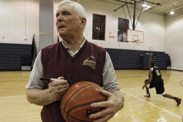 FILE - In this Wednesday, Feb. 2, 2011, file photo, Bob Hurley, head coach of the St. Anthony High School boys' basketball team, signs a game ball in Jersey City, N.J. In a half century at St. Anthony's, Hall of Fame basketball coach Bob Hurley has won on an almost unparalleled level in high school. But now the school that has been a haven to the poor seeking a Roman Catholic education could soon be closing its doors. (AP Photo/Julio Cortez, file)