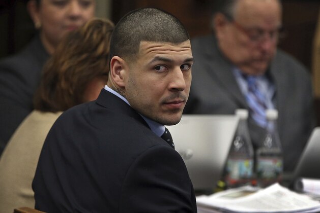 Former New England Patriots tight end Aaron Hernandez looks back during his double murder trial in Suffolk Superior Court in Boston, Wednesday, April 5, 2017.  Hernandez is standing trial for the July 2012 killings of Daniel de Abreu and Safiro Furtado, who he encountered in a Boston nightclub. The former NFL player is already serving a life sentence in the 2013 killing of semi-professional football player Odin Lloyd.  (Nancy Lane/The Boston Herald via AP, Pool)