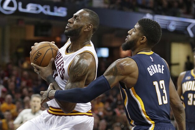 Cleveland Cavaliers' LeBron James, left, drives past Indiana Pacers' Paul George in the first half of an NBA basketball game, Sunday, April 2, 2017, in Cleveland. (AP Photo/Tony Dejak)