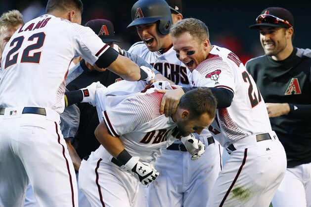Arizona Diamondbacks' Chris Owings, front, celebrates his walk-off single against the San Francisco Giants with Jake Lamb (22), Paul Goldschmidt, second from left, Brandon Drury, second from right, and Robbie Ray, right, in an opening-day baseball game Sunday, April 2, 2017, in Phoenix. The Diamondbacks defeated the Giants 6-5. (AP Photo/Ross D. Franklin)