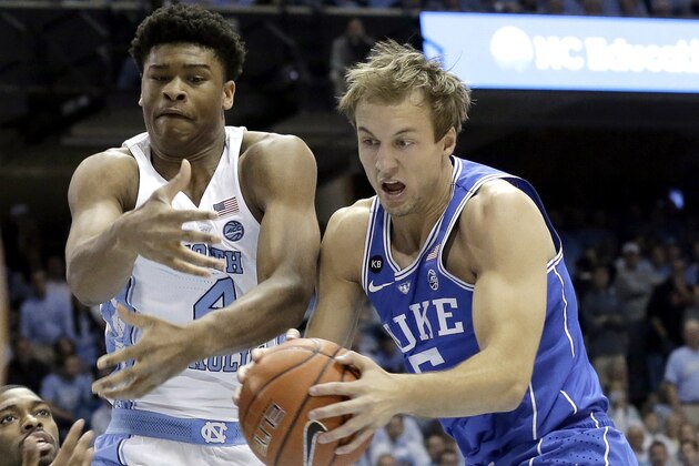 North Carolina's Isaiah Hicks, left, and Duke's Luke Kennard struggle for possession of the ball during the first half of an NCAA college basketball game in Chapel Hill, N.C., Saturday, March 4, 2017. (AP Photo/Gerry Broome)