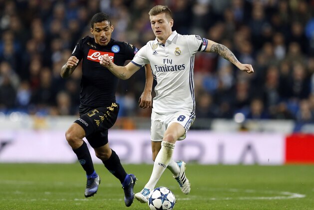 Real Madrid's Toni Kroos, right, runs with the ball followed by Napoli's Allan during the Champions League round of 16, first leg, soccer match between Real Madrid and Napoli at the Santiago Bernabeu stadium in Madrid, Wednesday Feb. 15, 2017. (AP Photo/Francisco Seco)
