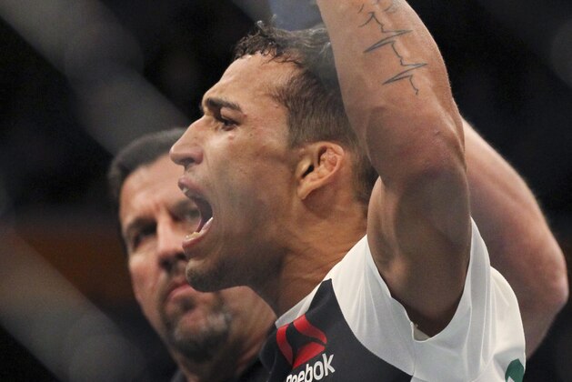 Charles Oliveira celebrates his victory over Will Brooks during a lightweight mixed martial arts bout at UFC 210, Saturday, April 8, 2017, in Buffalo, N.Y. (AP Photo/Jeffrey T. Barnes)