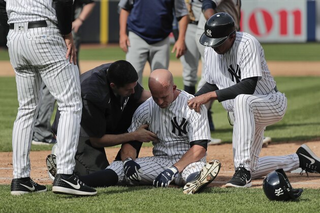 New York Yankees trainers and managers tend to Brett Gardner after Gardner collided with Tampa Bay Rays first baseman Rickie Weeks who was reaching for an errant throw during the sixth inning of a baseball game, Wednesday, April 12, 2017, in New York. (AP Photo/Julie Jacobson)